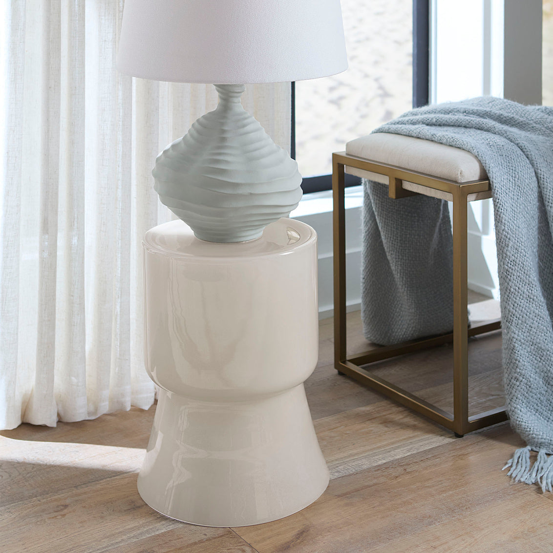 White side table with a lamp in a room setting